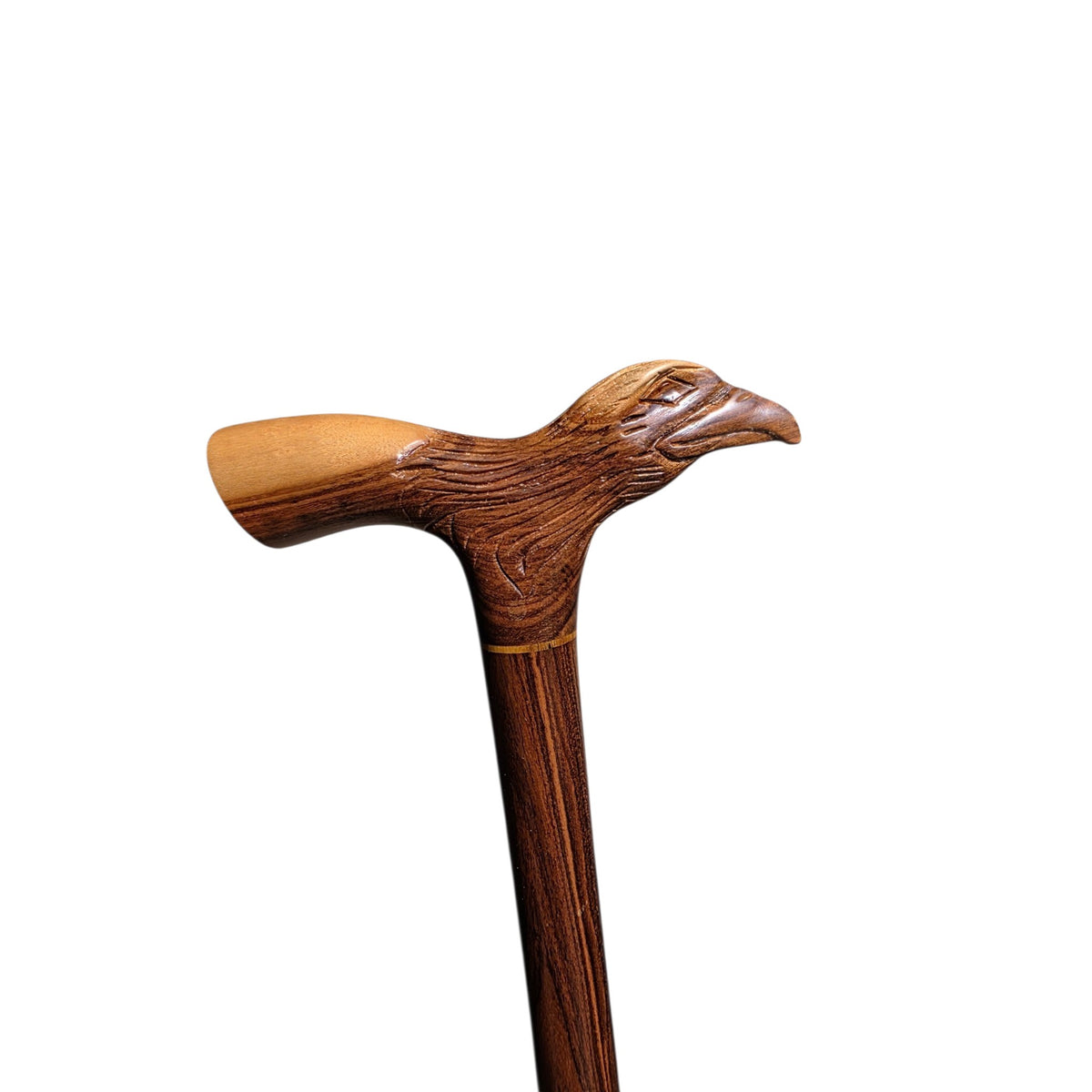 Hand-carved eagle head on the derby grip of a laurel wood walking cane, with the pale palm rest behind it