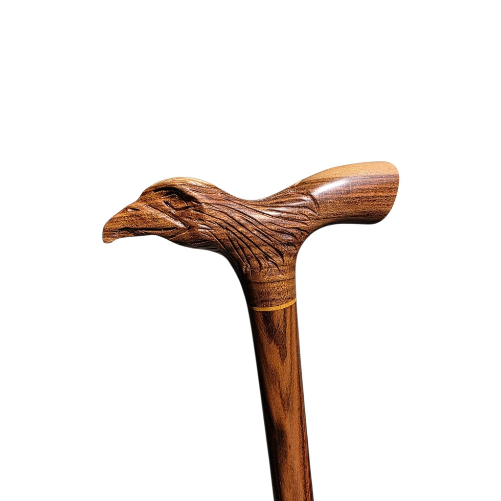 Close profile of the carved eagle head, with incised feather lines sweeping back along the neck