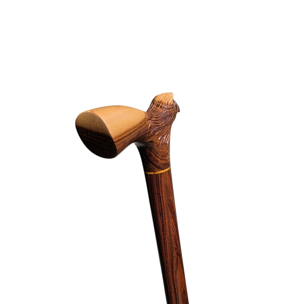 The pale palm rest of the eagle derby cane, with the carved head behind it