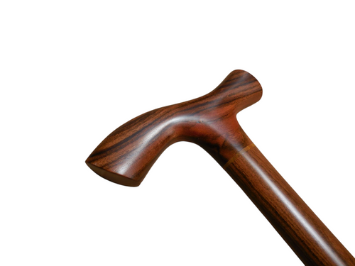 Tikal walking cane handle angled to the left, showing the sweep of the T-top into the laurel wood shaft