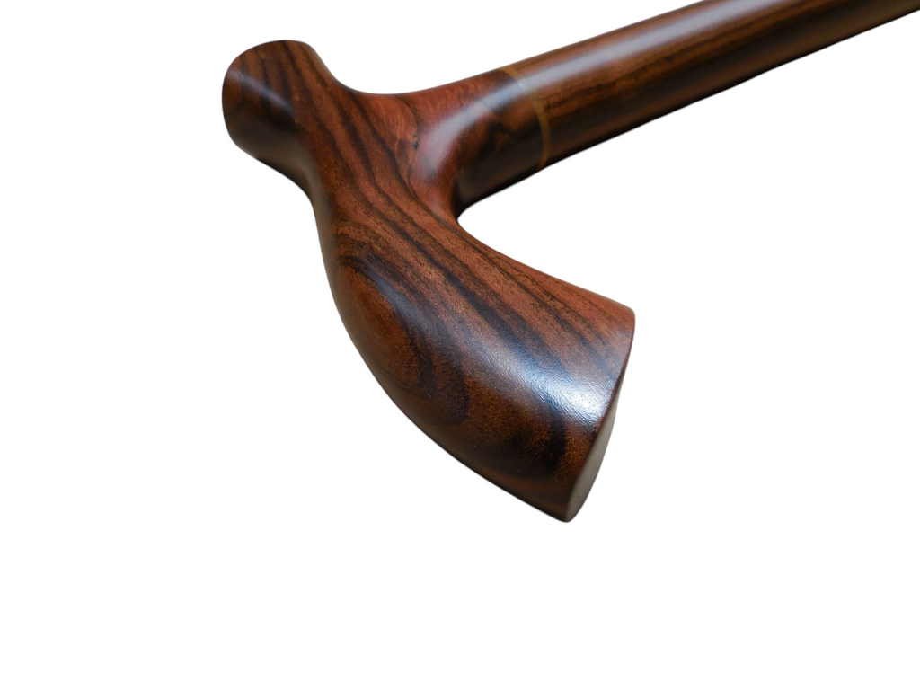 Tikal laurel wood cane handle at an angle with the shaft running diagonally out of frame